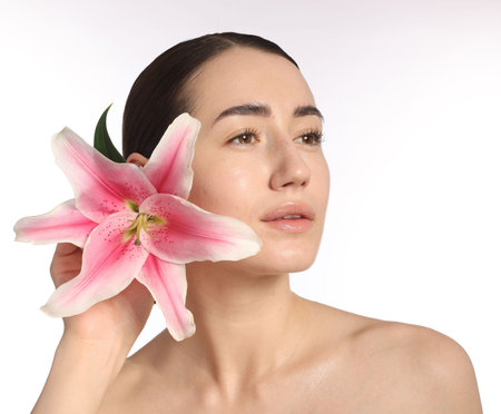 Beautiful woman with lily flower after spa treatment on white background, closeupの写真素材