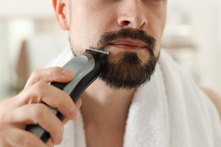 Man shaving with trimmer at home, closeupの写真素材