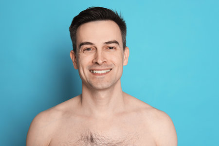 Smiling man after shaving on light blue backgroundの写真素材