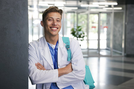 Medical student in uniform with backpack indoors, space for textの写真素材