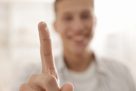 Man with contact lens at home, selective focusの写真素材