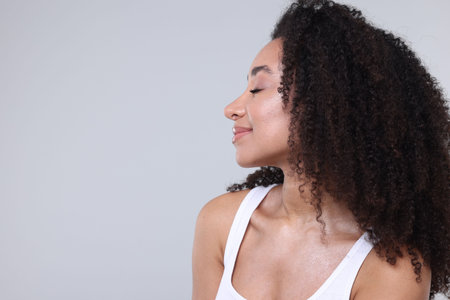 Beautiful Brazilian woman with healthy skin on gray background. Space for textの写真素材