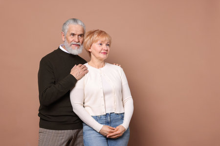 Lovely senior couple on beige background. Space for textの写真素材