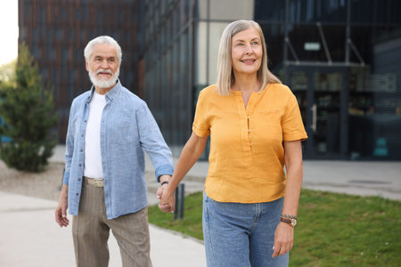 Lovely senior couple walking together on city streetの写真素材
