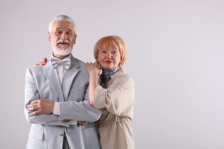 Lovely senior couple together on light gray background, space for textの写真素材