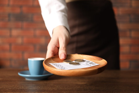 Waitress taking tips from wooden table in cafe, closeupの写真素材