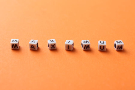 Word Maximum made of cubes on orange backgroundの写真素材