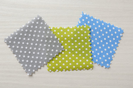 Samples of different fabrics on white wooden table, flat lay