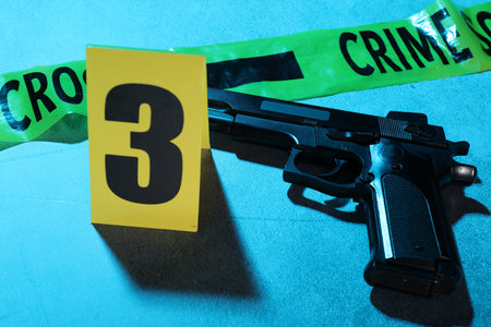 Forensic expertise. Crime scene tape and gun on blue background, closeup. Color toned effectの写真素材