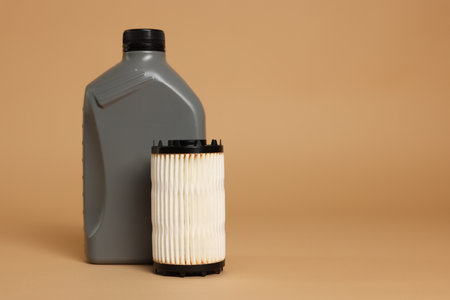 Motor oil in plastic canister and filter on beige background, space for textの写真素材