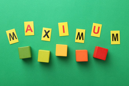 Word Maximum and colorful cubes on green background, flat layの写真素材