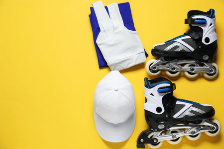 Flat lay composition with roller skates on yellow background. Space for text