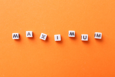 Word Maximum made of cubes on orange background, top viewの写真素材