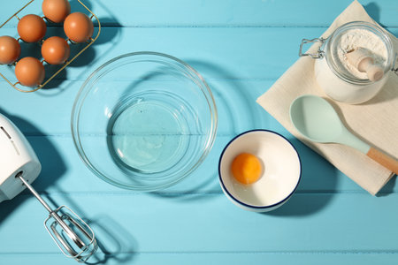 Making whipped cream. Bowl, hand mixer and ingredients on light blue wooden table, flat layの写真素材