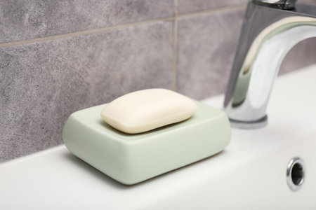 Soap bar near faucet on sink in bathroom, closeupの写真素材