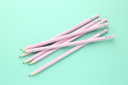 Many graphite pencils with erasers on turquoise background, flat layの写真素材