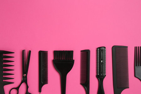Different hairdresser's tools on pink background, flat lay. Space for textの写真素材