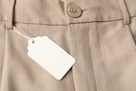Cardboard tag on beige pants, above viewの写真素材