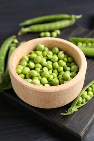 Fresh ripe green peas on black wooden table, closeupの写真素材