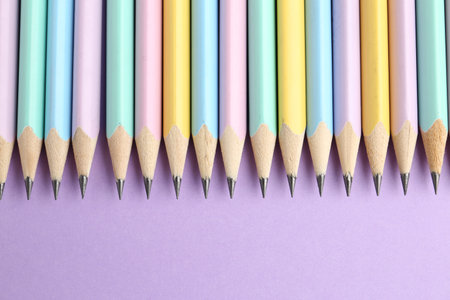 Many graphite pencils on violet background, flat lay. Space for textの写真素材