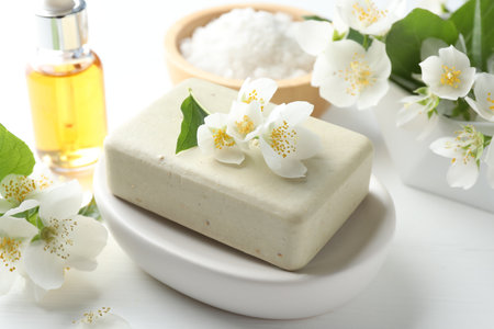 Soap bar, sea salt, essential oil and jasmine flowers on white wooden table, closeupの写真素材