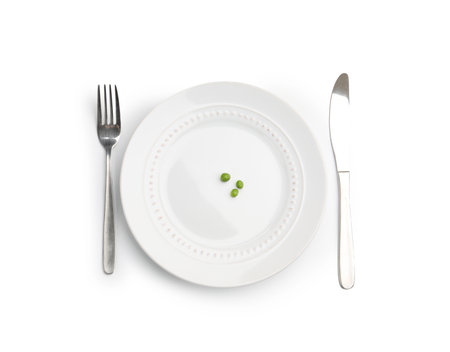 Plate with fresh green peas and cutlery isolated on white, top viewの写真素材