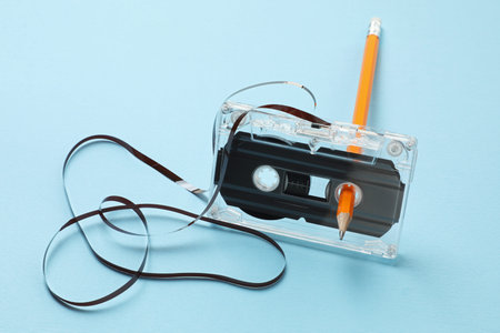 Rewinding audio cassette with pencil on light blue backgroundの写真素材
