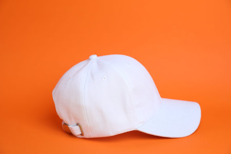 One white baseball cap on orange backgroundの写真素材