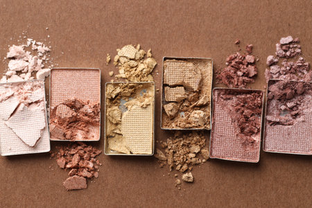 Beautiful eyeshadow refill pans on brown background, flat layの写真素材