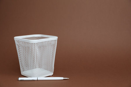 White pen and holder on brown background, space for textの写真素材