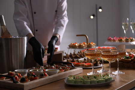 Chef arranging appetizers on buffet table, selective focus