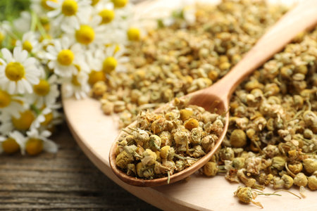 Dry, fresh chamomile flowers and spoon on table, closeupの写真素材
