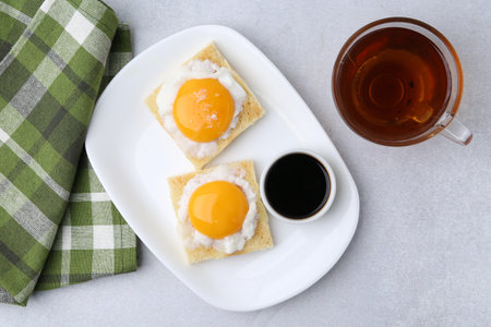 Traditional Asian breakfast with tasty kaya toasts and half-boiled eggs served on light gray table, flat layの写真素材