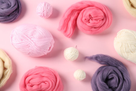 Felting wool and knitting yarn on pink background, flat layの写真素材