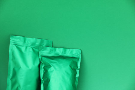Zipper stand-up pouches on green background, top view. Mockup for designの写真素材