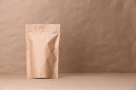 Zipper stand-up pouch on kraft paper background. Mockup for designの写真素材