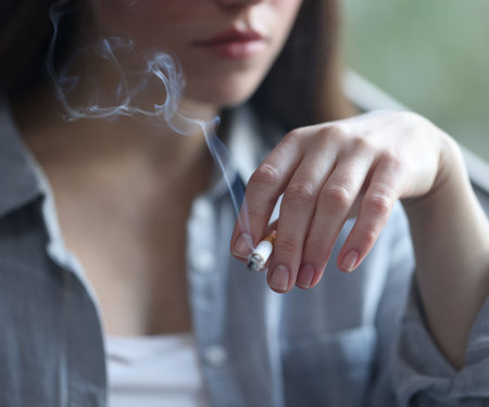 Woman smoking cigarette indoors, selective focus. Bad habitの写真素材