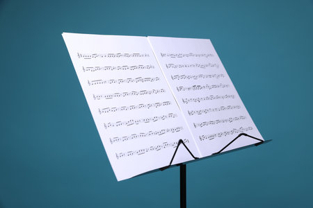 Note stand with music sheets on light blue background, closeupの写真素材