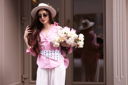 Stylish woman with bouquet of beautiful peonies outdoorsの写真素材