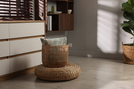 Stylish wicker pouf and home decor indoors. Space for textの写真素材