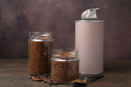 Instant coffee in jars and beans on wooden table, closeupの写真素材