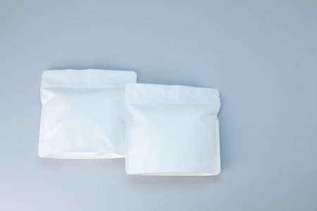 Two zipper stand-up pouches on light gray background, flat lay. Mockup for design