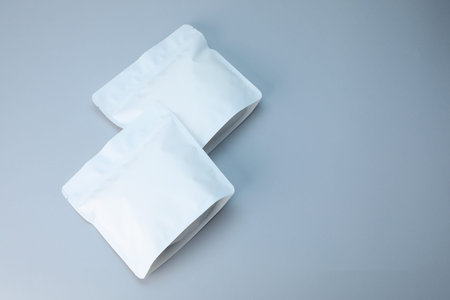 Two zipper stand-up pouches on light gray background, above view. Mockup for design