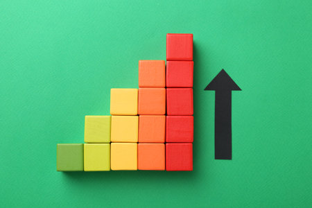 Maximum. Arrow and colorful cubes on green background, top viewの写真素材