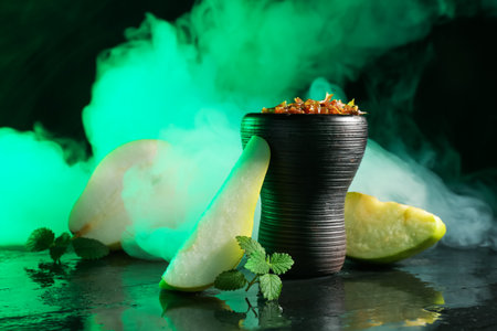 Hookah bowl with pear pieces, mint and smoke on black table, closeupの写真素材