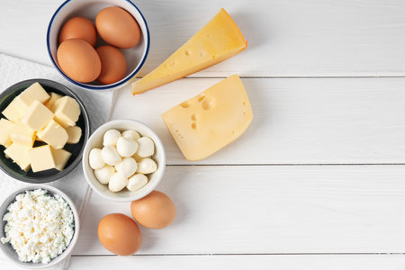 Different dairy products and eggs on white wooden table, flat lay. Space for textの写真素材