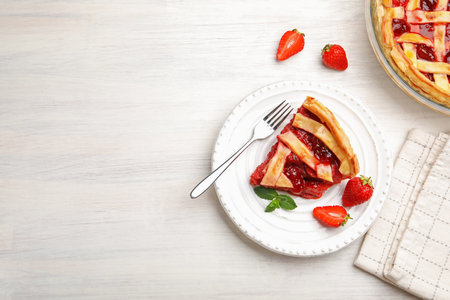 Piece of tasty strawberry pie and berries on white wooden table, flat lay. Space for textの写真素材