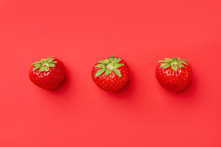 Fresh ripe strawberries on red background, flat layの写真素材