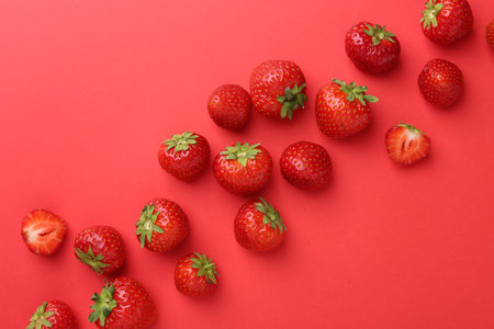 Fresh ripe strawberries on red background, flat lay. Space for textの写真素材