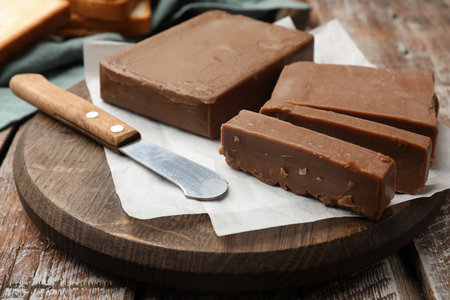 Tasty chocolate butter and knife on wooden table, closeupの写真素材